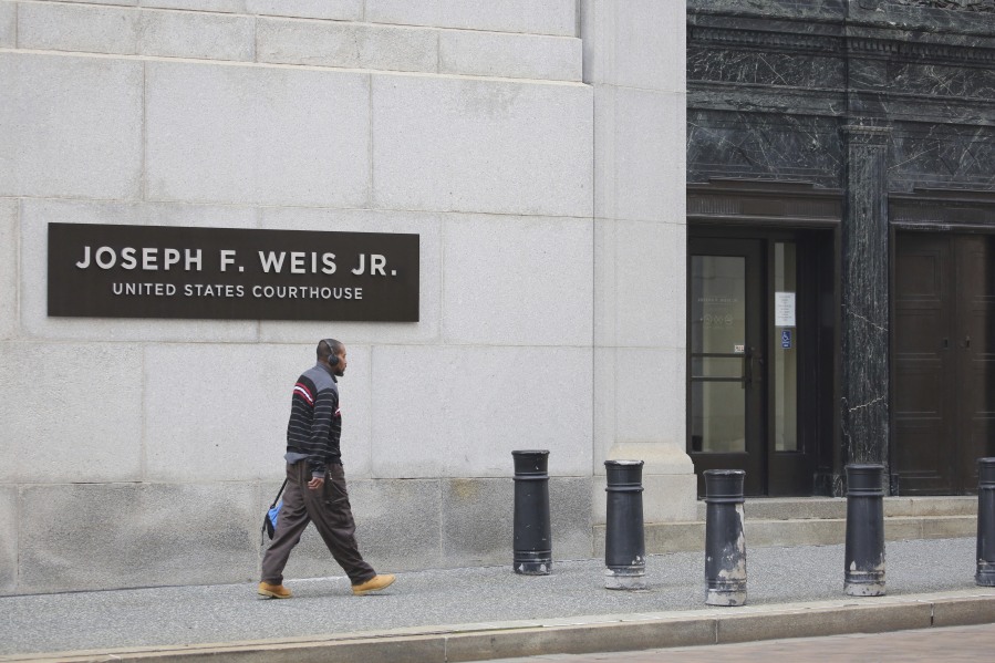 A man walks by the Joseph F. Weis Jr. United States Courthouse as a federal jury continues to deliberate the sentencing of Robert Bowers, in Pittsburgh, Wednesday, Aug 2, 2023. The jury will decide if Bowers receives a life sentence or the death penalty for killing 11 people at the Tree of Life synagogue in Pittsburgh in 2018.