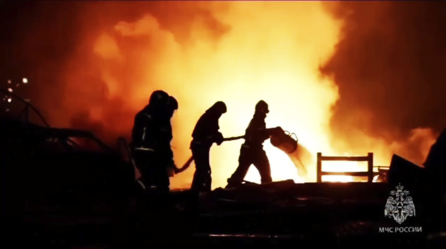 In this image made from video provided by the Russian Emergency Situations Ministry press service, firefighters work to extinguish a fire at a petrol station on a road near Makhachkala, the capital of Dagestan, Russia, late Monday, Aug. 14, 2023.