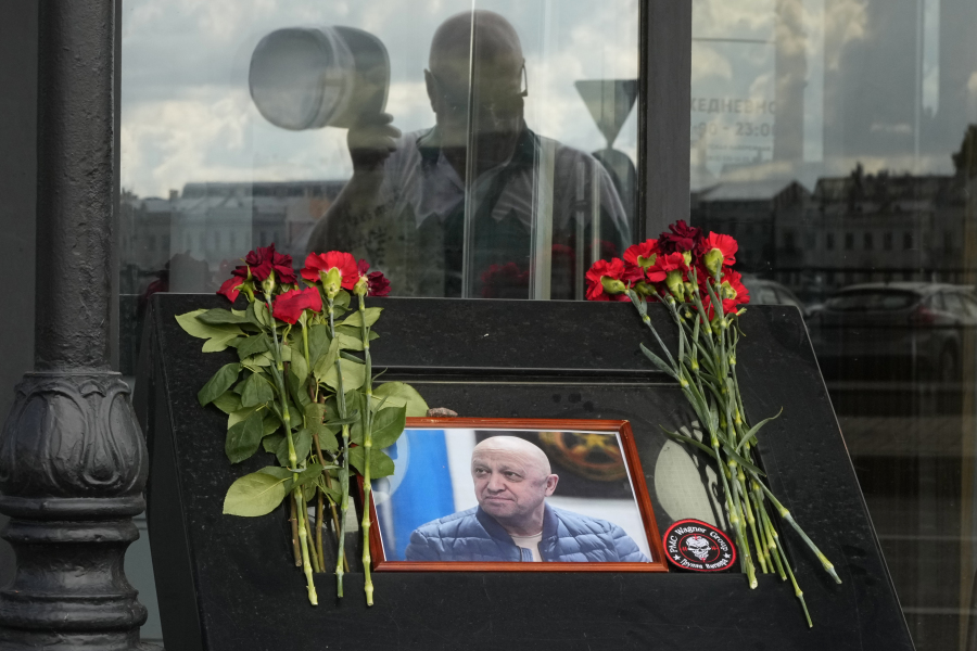 A man looks at a portrait of the owner of private military company Wagner Group Yevgeny Prigozhin installed at an informal memorial at a cafe owned by a Prigozhin's company in St. Petersburg, Russia, Friday, Aug. 25, 2023. A preliminary U.S. intelligence assessment has found that the plane crash presumed to have killed Wagner leader Yevgeny Prigozhin was intentionally caused by an explosion.