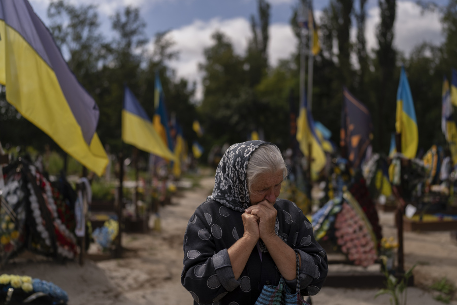 Svitlana Sushko, 62, sobs while visiting the grave of her youngest son, a Ukrainian soldier who was killed last year in the war against Russia, in Kyiv, Ukraine, Thursday, Aug. 3, 2023. (AP Photo/Jae C.