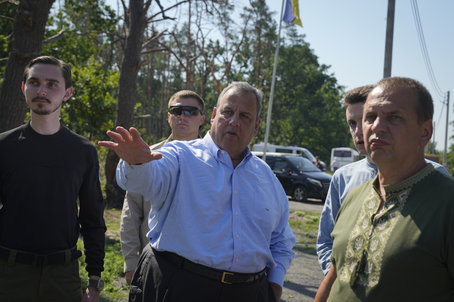Republican presidential candidate former New Jersey Gov. Chris Christie, center, speaks with activists as he visits a former defence line from Russian massive offensive in March 2022 in the village of Moshchun, outskirts of Kyiv, Ukraine, Friday, Aug. 4, 2023.