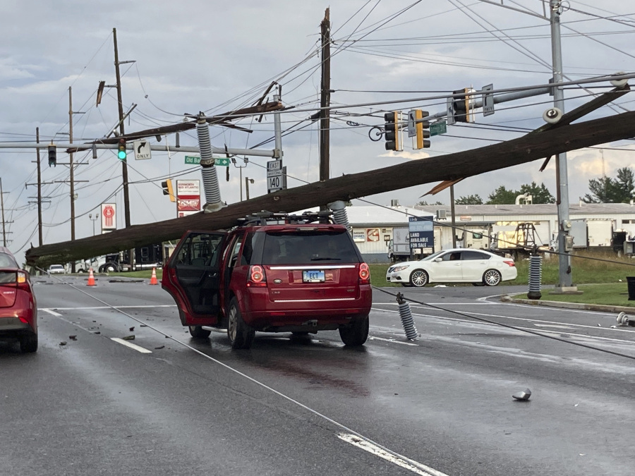 A fallen pole rests on a car at the intersection of Route 140 and Market Street in Westminster., Md., on Monday, Aug. 7, 2023.