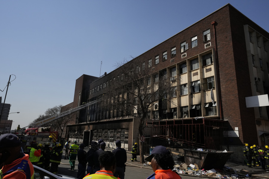 People watch emergency services at the scene of a deadly blaze in downtown Johannesburg, Thursday, Aug. 31, 2023. Dozens died when a fire ripped through a multi-story building in Johannesburg, South Africa's biggest city, emergency services said Thursday.