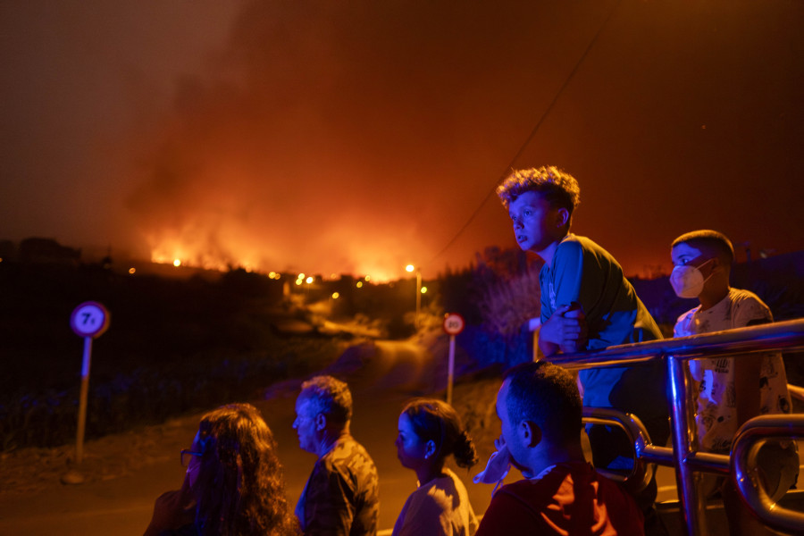 Local residents try to reach their houses in Benijos village as police block the area as fire advances in La Orotava in Tenerife, Canary Islands, Spain on Saturday, Aug. 19, 2023. Firefighters have battled through the night to try to bring under control the worst wildfire in decades on the Spanish Canary Island of Tenerife, a major tourist destination. The fire in the north of the island started Tuesday night and has forced the evacuation or confinement of nearly 8,000 people.