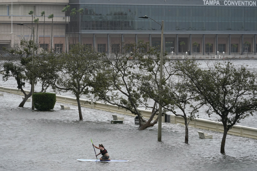 Zeke Pierce rides his paddle board down the middle of a flooded Bayshore Blvd in downtown in Tampa, Fla., Wednesday, Aug. 30, 2023.  Hurricane Idalia steamed toward Florida's Big Bend region Wednesday morning, threatening deadly storm surges and destructive winds in an area not accustomed to such pummeling.