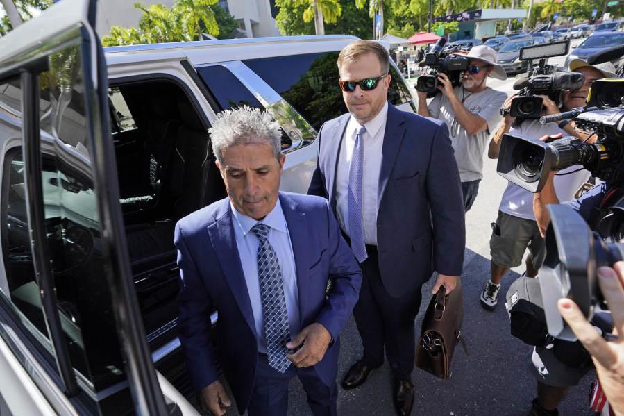 FILE - Carlos De Oliveira, center, an employee of Donald Trump's Mar-a-Lago estate, arrives for a court appearance with attorney John Irving, at the James Lawrence King Federal Justice Building, July 31, 2023, in Miami. The property manager of Donald Trump's Mar-a-Lago estate and an aide to the former president are due back in federal court in Florida to face charges in the case accusing Trump of illegally hoarding classified documents at his club.