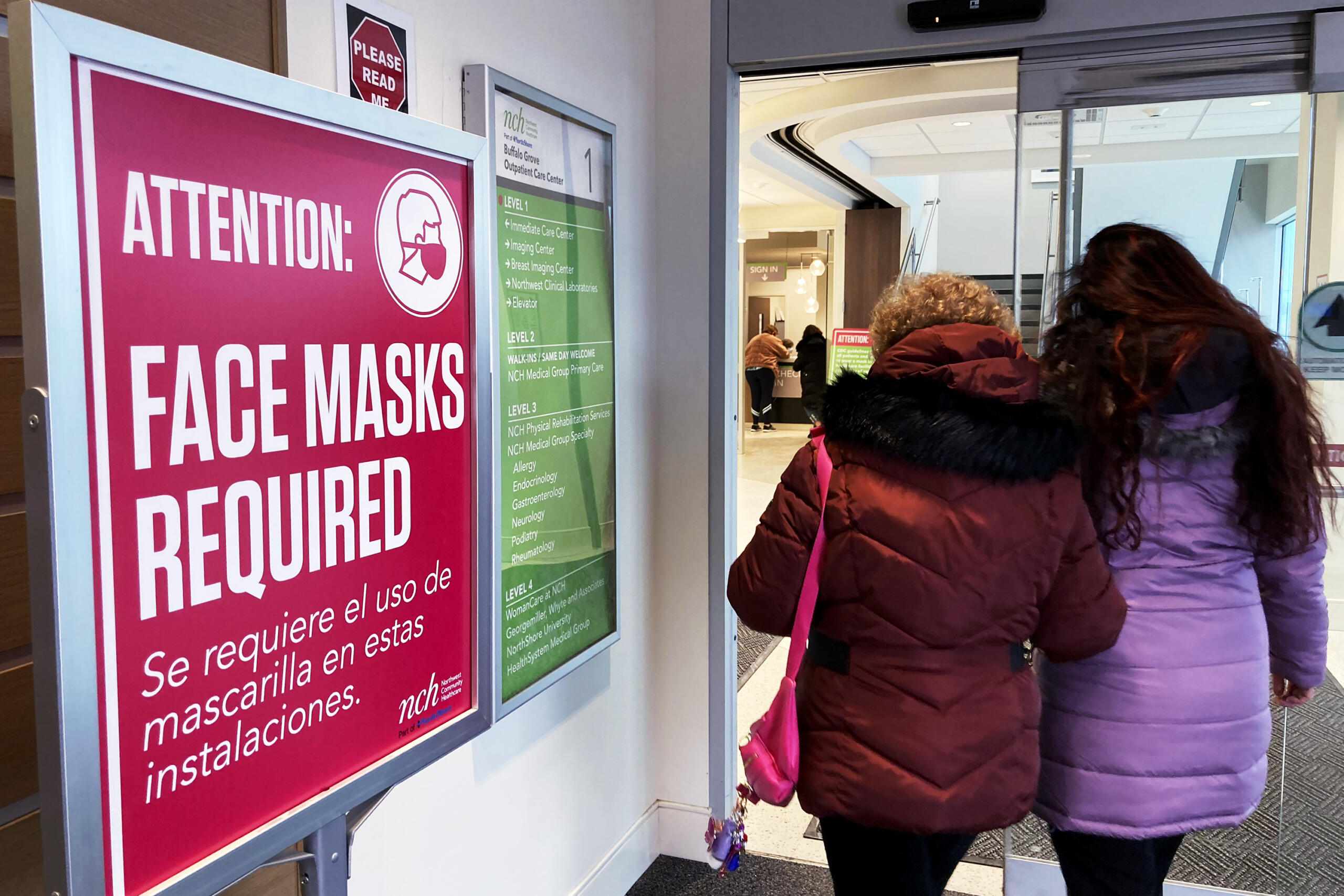 A sign announcing a face mask requirement is displayed at a hospital in Buffalo Grove, Ill., Friday, Jan. 13, 2023. COVID-19 hospital admissions are inching upward in the United States since early July 2023. It's a small-scale echo of the three previous summers. (AP Photo/Nam Y.