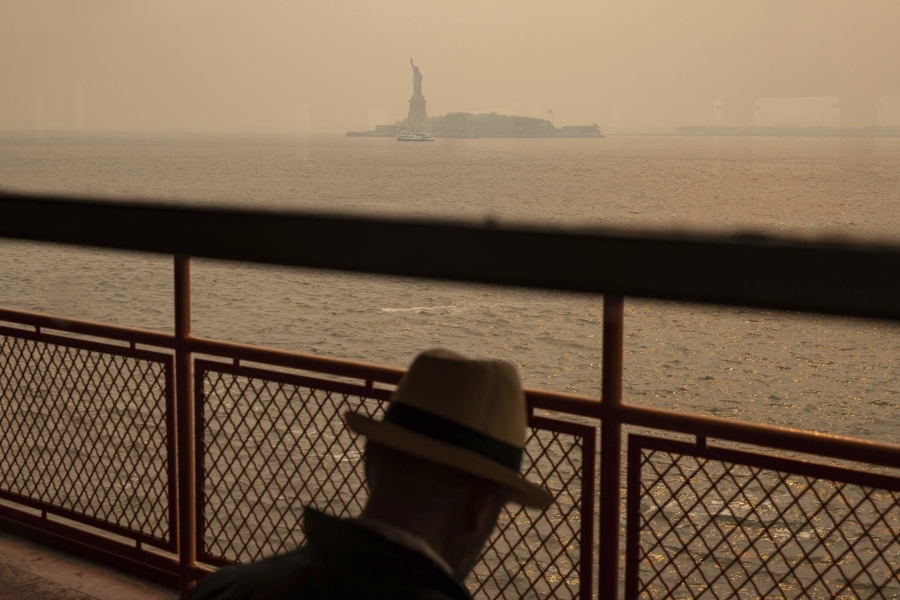 FILE - The Statue of Liberty, covered in a haze-filled sky, is photographed from the Staten Island Ferry, June 7, 2023, in New York. The smoke from Canadian wildfires that drifted into the U.S. led to a spike in people with asthma visiting emergency rooms -- particularly in the New York area. The U.S. Centers for Disease Control and Prevention published two studies Thursday, Aug. 24 about the health impacts of the smoke, which shrouded city skylines with an orange haze in late spring, and a medical journal also released a study this week.
