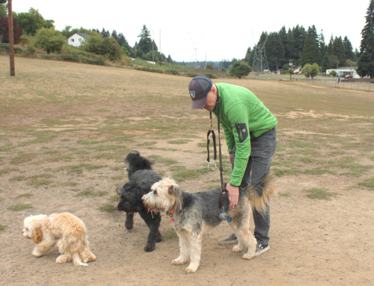 Scott Long of Vancouver, greets his dogs, 9-year-old Beni and 6-year-old Darby, right, at Ike Memorial Dog Park in Vancouver. Six years after an off-leash park in Washougal closed, the idea is  under consideration in Camas.