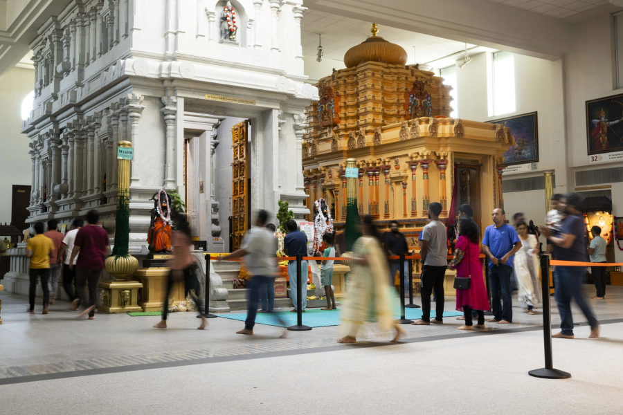People walk around the altars of the deities in prayer Aug.