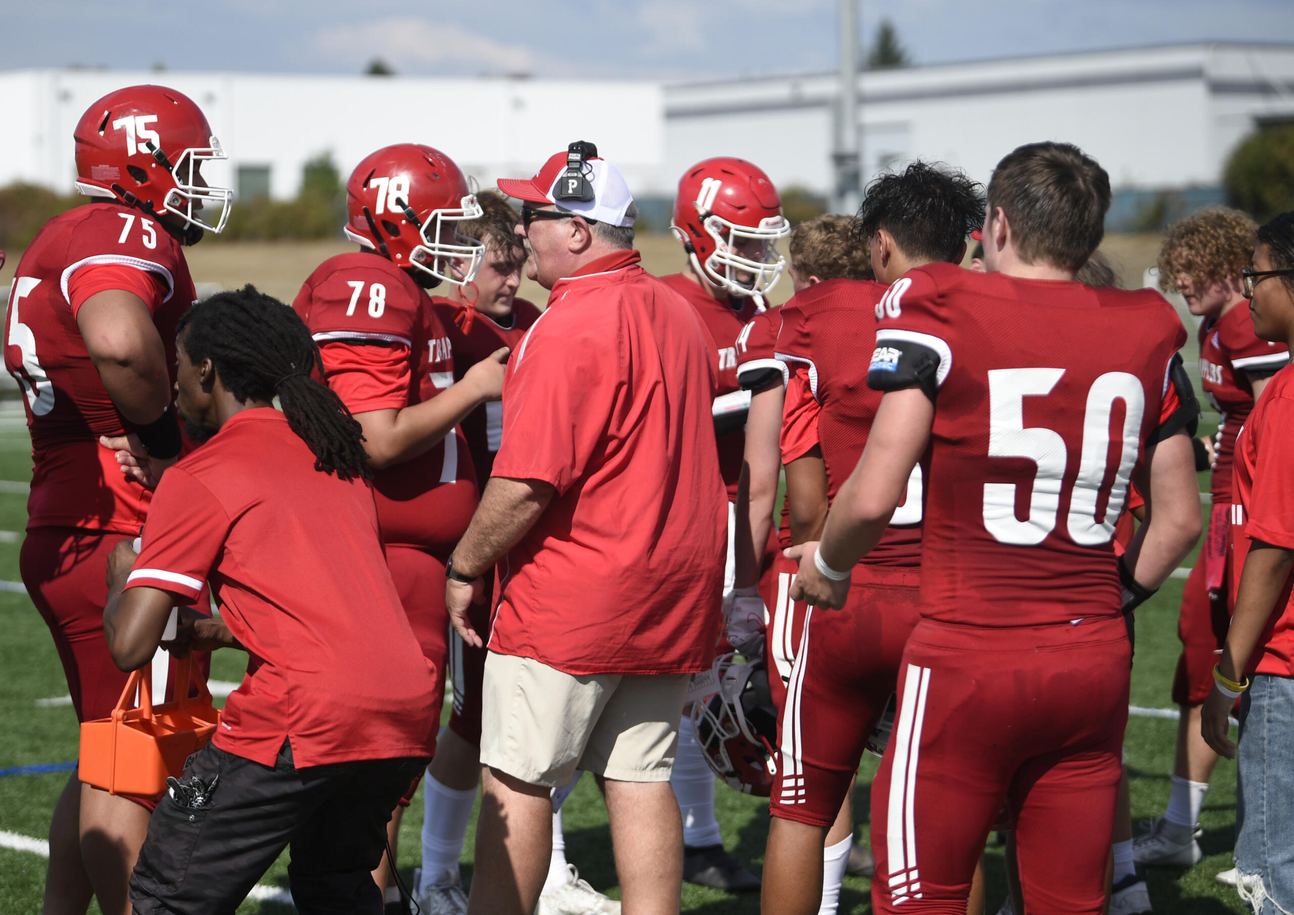 Fort Vancouver head coach Doug Bilodeau, center, talks to senior Ryan Faumuina (75) during a water break on Saturday, Sept. 2, 2023, at Fort Vancouver High School.