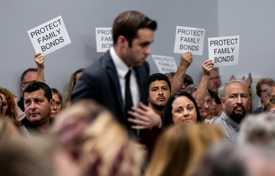 Attendees in support of a parental notification policy hold up signs stating ???Protect Family Bonds??? during a Murrieta Valley Unified school board meeting.