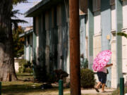A resident makes her way home at the Imperial Courts housing project in Watts on Aug. 1, 2023. Watts has been the site of violence in recent weeks with multiple people dying and 9 people being shot in Imperial Courts and Jordan Downs housing projects.