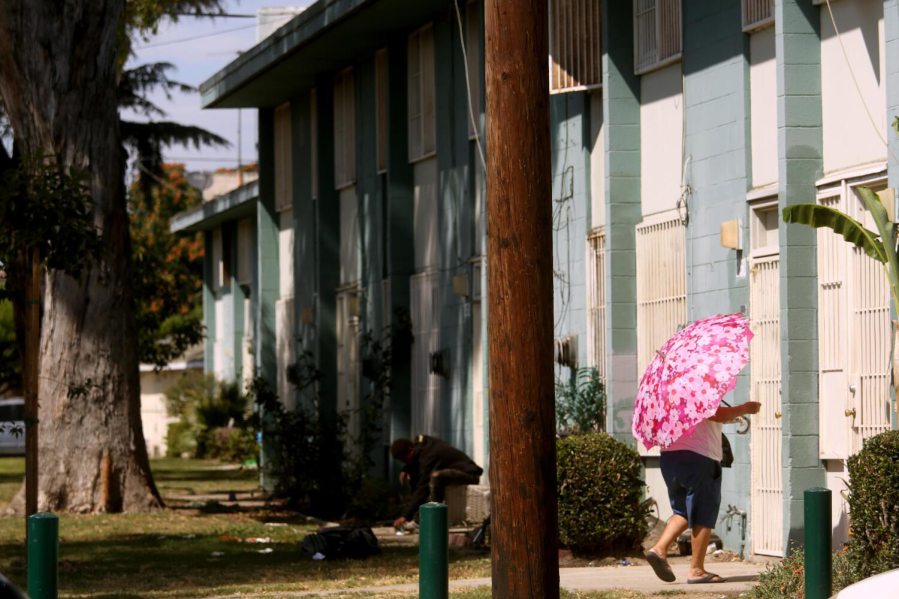 A resident makes her way home at the Imperial Courts housing project in Watts on Aug. 1, 2023. Watts has been the site of violence in recent weeks with multiple people dying and 9 people being shot in Imperial Courts and Jordan Downs housing projects.