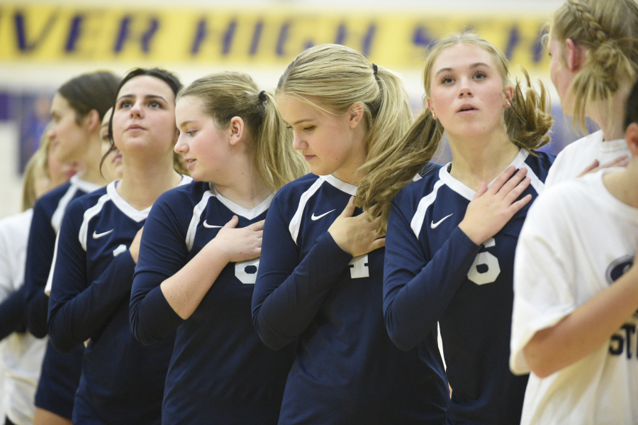 Skyview volleyball players pose during the national anthem before a match against Columbia River on Wednesday, Sept. 6, 2023 at Columbia River High School.