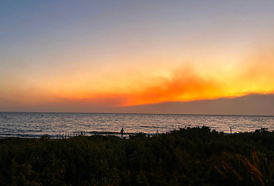 Smoke pools in the air from fires burning on Maui as the sun sets in Kihei, Hawaii, on Aug. 8, 2023. The fires are gone and tourism has yet to bounce back on the island.