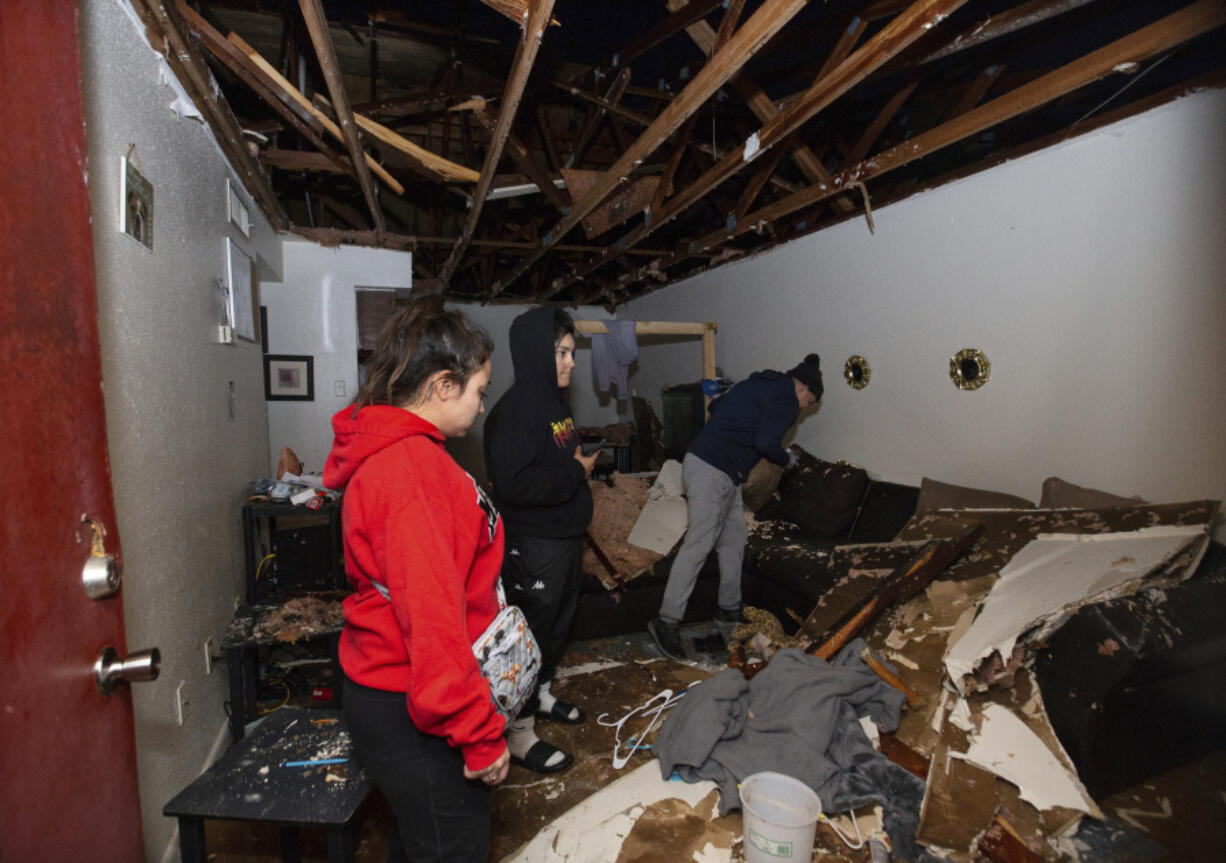 Jorge Amezquita, from right, cousin Adalene Castillo and girlfriend Cassandra Duarte look for a TV remote under debris after a tornado ripped the roof off the apartment on Jan. 24 at Beamer Place Apartments in Houston. When natural or man-made disasters happen, renters insurance can mean the difference between catastrophe and stability.