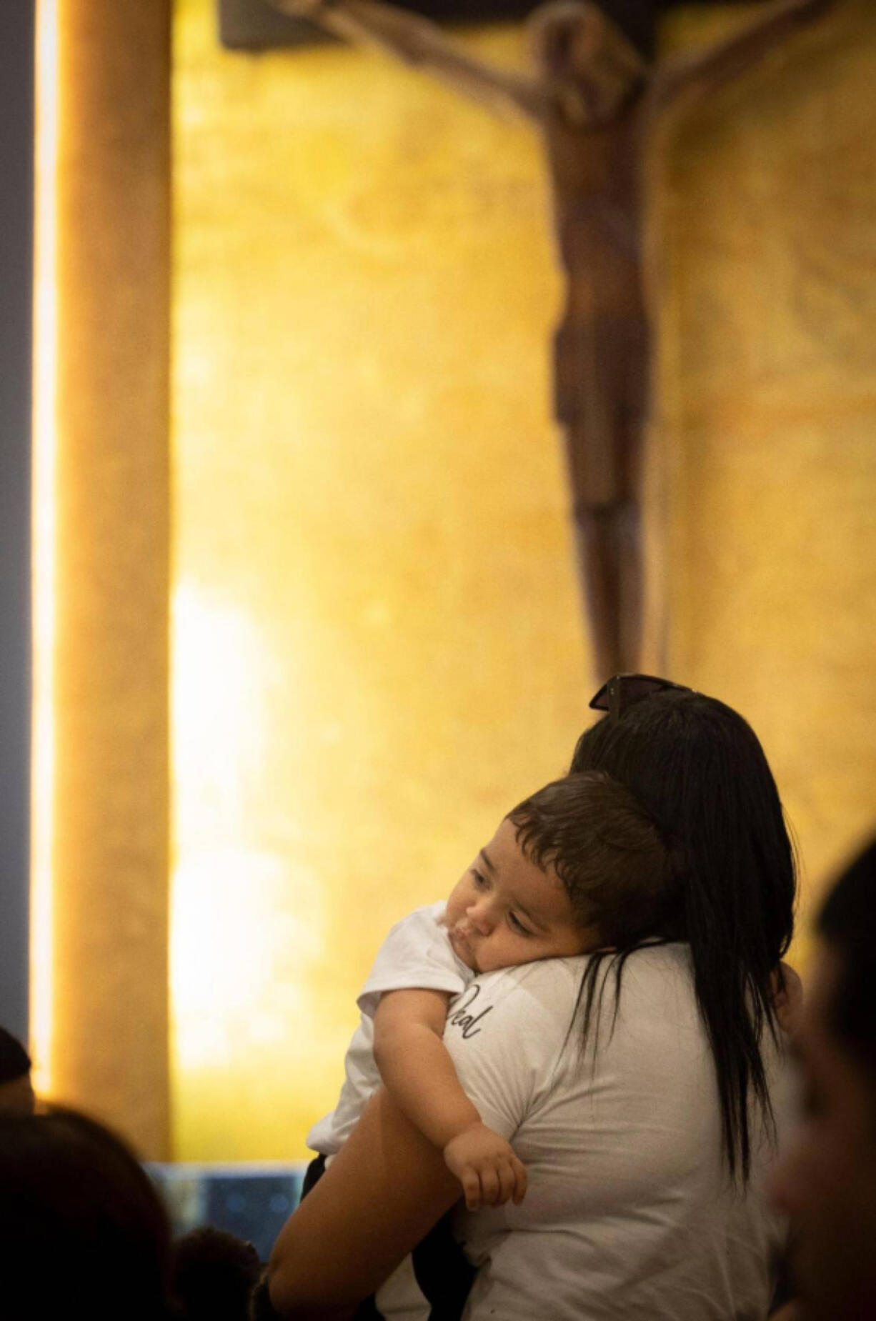 Maria Chirinos holds her son, Jhonder, 1, during mass before his baptism ceremony on Sunday, Sept. 10, 2023, at Corpus Christi Catholic Church in Miami. Many of the children baptized were migrant refugees being welcomed into the church as part of an outreach effort by the Hermanos de la Calle, a organization that combats homelessness.