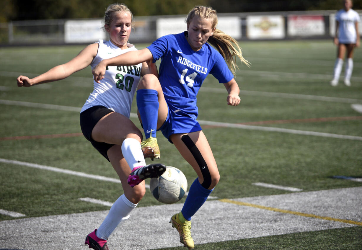 Tumwater’s Kayla Pope, left, and Ridgefield’s Ellie Wilson lift their cleats while going for a loose ball during a non-league soccer match on Saturday, Sept. 16, 2023, at Ridgefield High School.