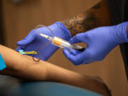 Phlebotomist Latrell Anderson draws blood last week at the AIDS Healthcare Foundation Wellness Center in Los Angeles.