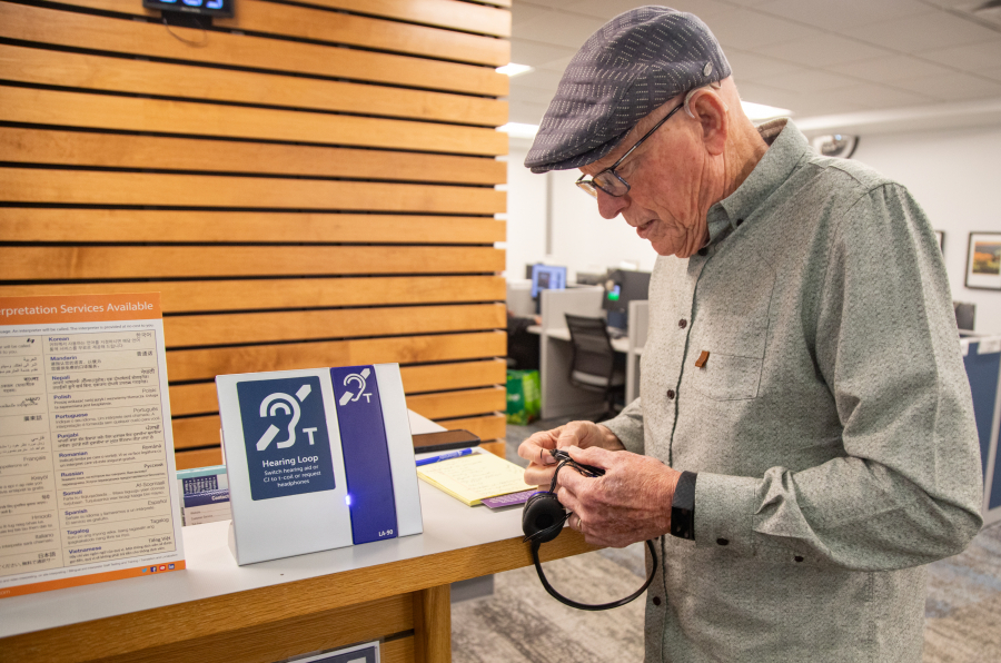 Larry Wonnacott fiddles with headphones at a hearing loop station in the Bellingham Public Library on Sept. 13. The loop system is one of several around Bellingham that amplify voices through people's hearing aids or through the headphones.