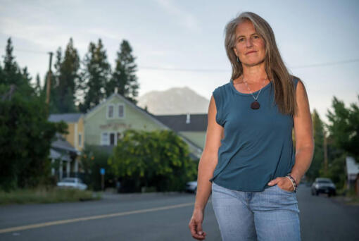 Angelina Cook, a Democrat and longtime Siskiyou County resident, is running her second campaign for a seat on the non-partisan Siskiyou County Board of Supervisors. She stands on Main Street in McCloud, California, on Aug. 8, 2023, with Mount Shasta in the distance.