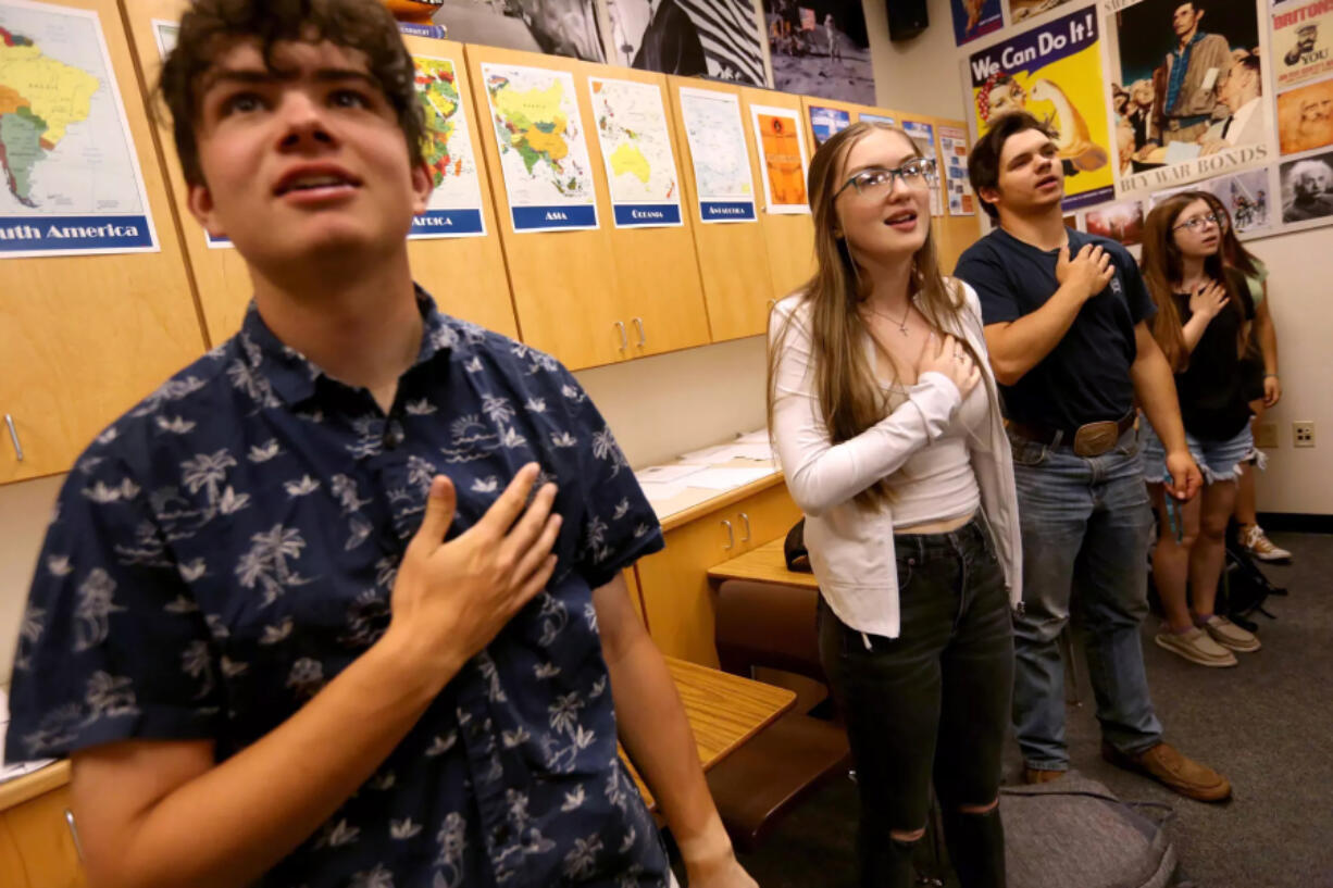 Justin Walton, Linda Plumlee and other high school seniors say the Pledge of Allegiance at Modoc High School in Alturas, Calif. Student body president Plumlee, now 18, has been on her own since 14.