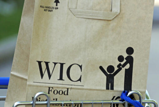 FILE - In this Oct. 3, 2013 file photo, a special supplemental nutrition program for women, infants and children, better known as WIC, bag sits on a shopping cart waiting to be loaded into a recipient's vehicle at a center in Jackson, Miss.  (AP Photo/Rogelio V.
