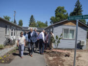 Washington Gov. Jay Inslee talks with local officials and members of the community in July while getting a tour of Fruit Valley Terrace, an affordable housing complex of tiny homes in west Vancouver.