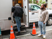 Brendan Medbury, hospitality and engagement worker with Evergreen Treatment Services, holds the door for a client Friday morning in the Belltown neighborhood of Seattle, on Aug. 18, 2023.