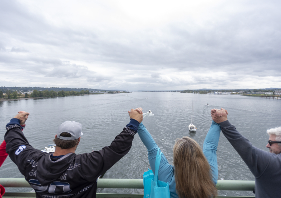 People hold hands and form a link from Washington to Oregon during the Hands Across the Bridge event that celebrates those in any stage of addiction recovery.