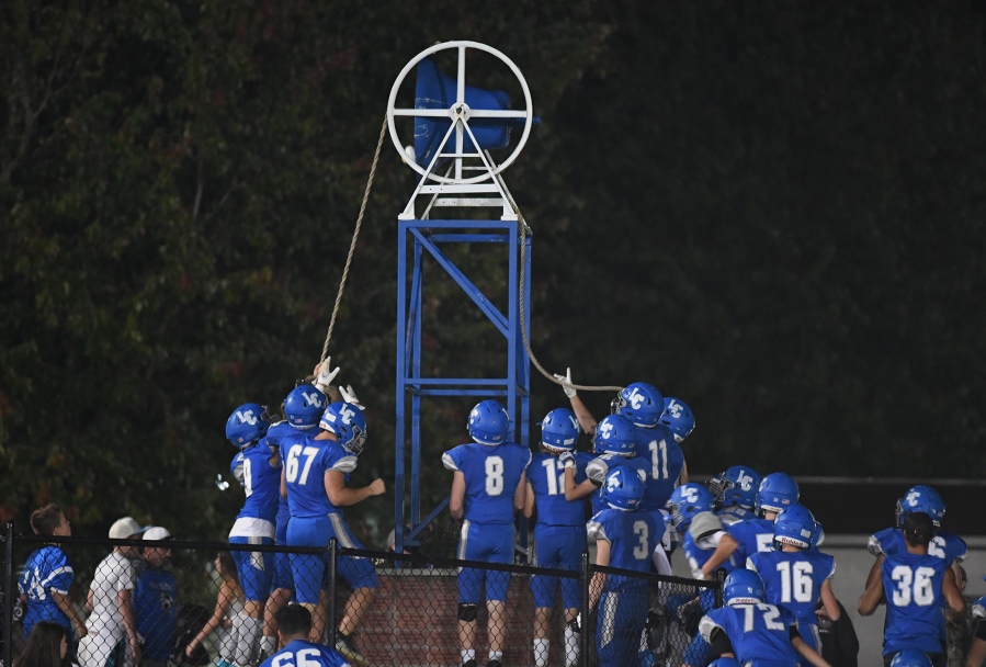 La Center players ring a bell in celebration Friday, Sept. 8, 2023, after the Wildcats' 24-8 win against Woodland at La Center High School.