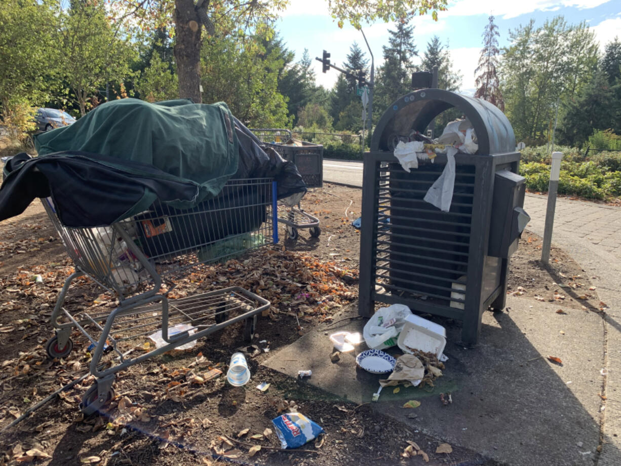 A trash can shared between the public and people living at the Burnt Bridge Creek Trail camp in Vancouver overflows with garbage.