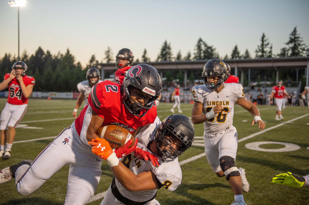 Camas RB Titan Brody (2) rushes for a first down before getting tackled by Lincoln's Sebatian Esekielu (8) during the Papermakers' non-league football game against the Abes on Friday, Sept. 15, 2023, at Doc Harris Stadium.