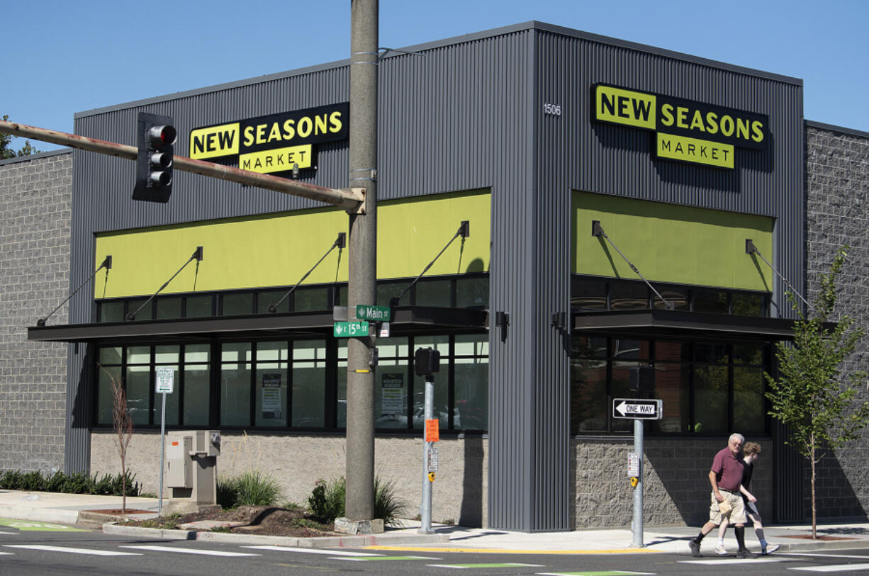 Pedestrians stroll past the Main Street New Seasons Market, which is set to open next month. Local leaders and businesses expect the store to not only provide greater access to groceries downtown but to link foot traffic between Vancouver's downtown and Uptown Village.