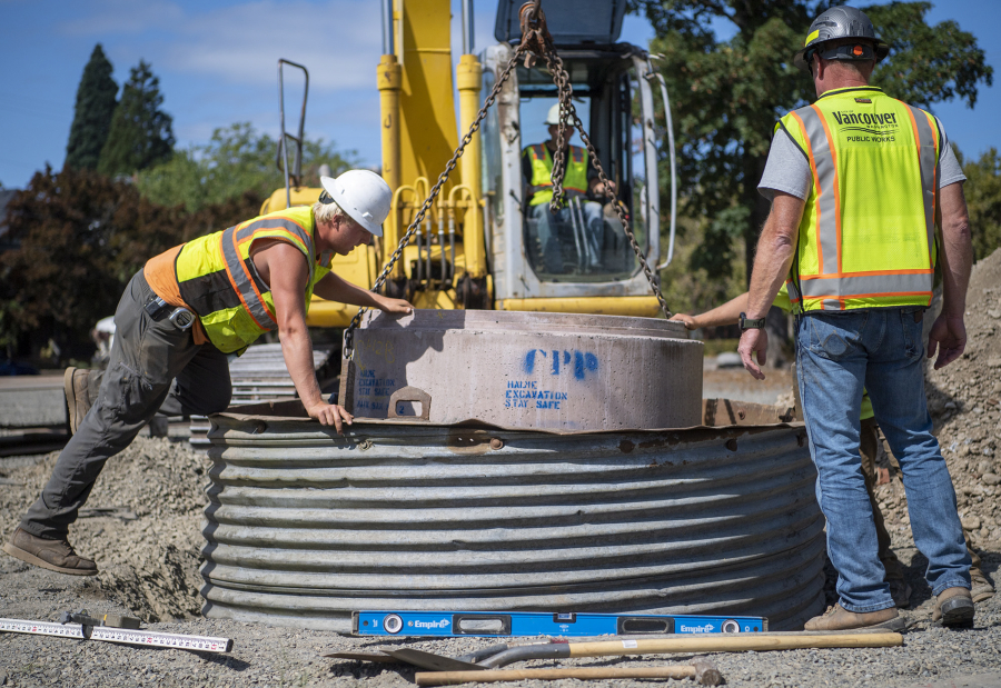 Workers install a concrete cylinder on West 11th Street in downtown Vancouver. The lot is the future site of the city's third Safe Stay transitional housing community, which was green-lighted in November 2022 by the Vancouver City Council. On Aug. 28, construction contracts were awarded to prepare the site for an estimated fall 2023 opening.
