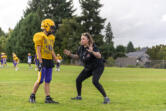 Columbia River assistant defensive coach Ruth Ingebrand, right, coaches a player Tuesday, Sept. 26, 2023, during football practice at Columbia River High School.
