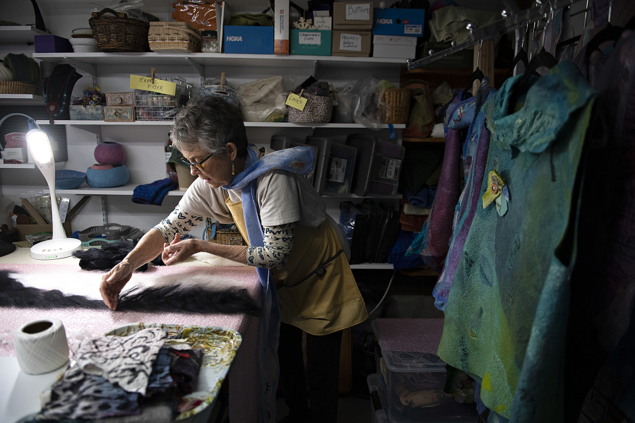 Local artist Patty White, who is visually impaired, uses a special light to help her see as she works on an unspun wool scarf in her Vancouver studio.