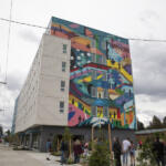 A colorful mural on the side of the new Fourth Plain Community Commons celebrates the diversity of the neighborhood and its residents. (Elayna Yussen for The Columbian)