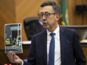 Clark County Prosecutor Tony Golik holds a photo of defendant Guillermo Raya Leon on Monday during the prosecution's closing arguments in Raya Leon's murder trial at the Clark County Courthouse.