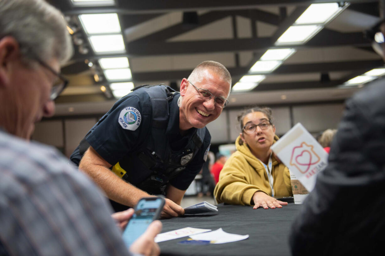 Vancouver Police officer Tyler Chavers, part of the Homeless Assistance Outreach Program, shares pamphlets and speaks to Vancouver residents at Monday night's city forum.