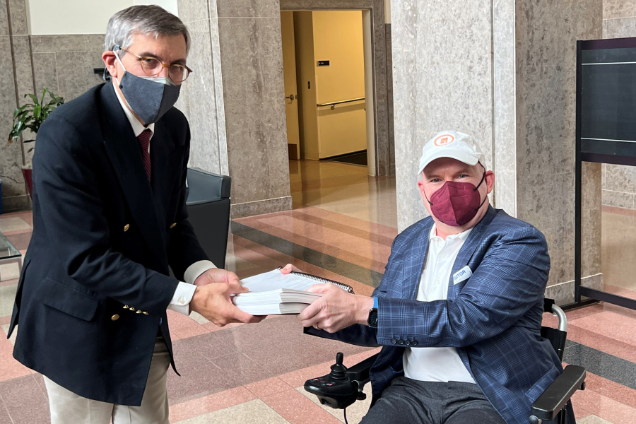 In this photo provided by I AM ALS, Dan Tate, right, delivers a printed petition from ALS patients and advocates to Dr. Peter Marks, left, director of the Food and Drug Administration's center for biologics at the FDA campus in Silver Spring, Md., on Dec. 14, 2022. The FDA meets this week to consider approval of an experimental treatment for Lou Gehrig's disease, the culmination of a yearslong lobbying effort by patients with the fatal, neurodegenerative disease. Those advocates still face one giant hurdle: FDA regulators say the treatment hasn't been shown to work. In documents posted Monday, Sept. 25, 2023 the FDA reiterated its longstanding position: drugmaker Brainstorm's lone study doesn't provide clear evidence that its stem cell-based therapy helps patients with ALS, or amyotrophic lateral sclerosis.