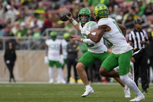 Oregon quarterback Bo Nix throws the ball to Oregon tight end Kenyon Sadiq, foreground right, during the first half of an NCAA college football game against Stanford on Saturday, Sept. 30, 2023, in Stanford, Calif. (AP Photo/Godofredo A.