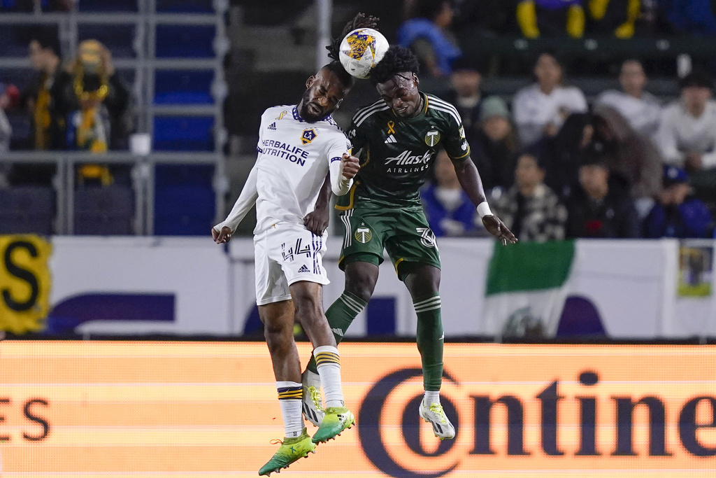 LA Galaxy defender Raheem Edwards, left, and Portland Timbers midfielder Santiago Moreno vie for the ball in the air during the second half of an MLS soccer match, Saturday, Sept. 30, 2023, in Carson, Calif.