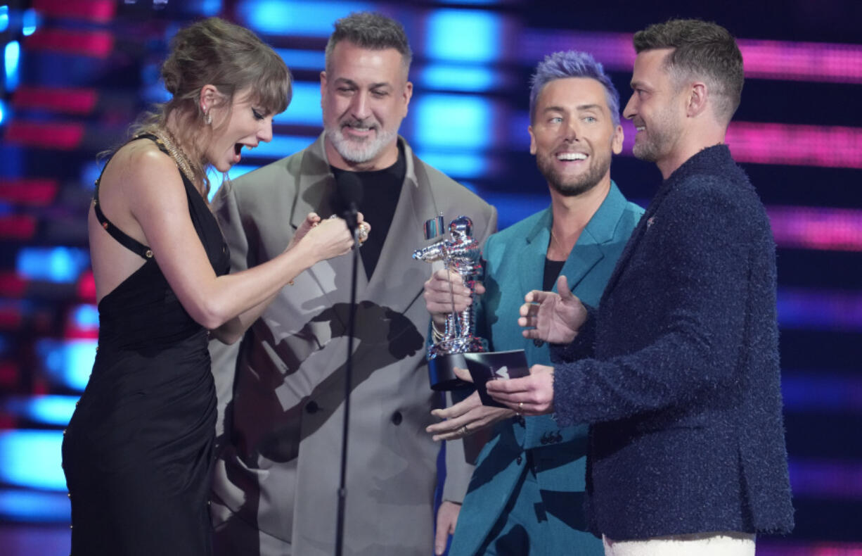 Joey Fatone, from center, Lance Bass, and Justin Timberlake of NSYNC present the award for best pop video to Taylor Swift, far left, for "Anti-Hero" during the MTV Video Music Awards on Tuesday at the Prudential Center in Newark, N.J.