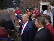 Former President Donald Trump holds a spatula with a hamburger on it as he works the grill during a stop at the Alpha Gamma Rho, agricultural fraternity, at Iowa State University before an NCAA college football game between Iowa State and Iowa, Saturday, Sept. 9, 2023, in Ames, Iowa.