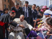 Pope Francis is greeted by Cardinal Giorgio Marengo, left, Apostolic Prefect of Ulaanbaatar, and faithful gathered outside the Apostolic Prefecture in Ulaanbaatar's Kahn Uul district, Friday, Sept. 1, 2023. Pope Francis is traveling to Mongolia to encourage one of the world's smallest and newest Catholic communities. It's the first time a pope has visited the Asian country and comes at a time when the Vatican's relations with Mongolia's two powerful neighbors, Russia and China, are once again strained.