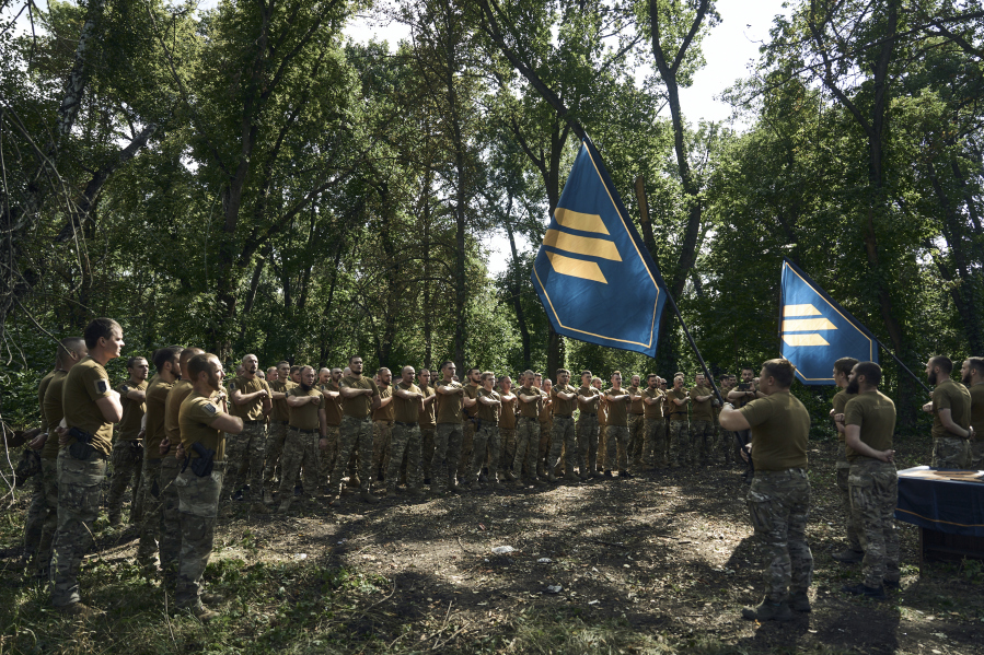 Soldiers of Ukraine's 3rd Separate Assault Brigade shout slogans as they stand in line, near Bakhmut, the site of fierce battles with the Russian forces in the Donetsk region, Ukraine, Sunday, Sept. 3, 2023.