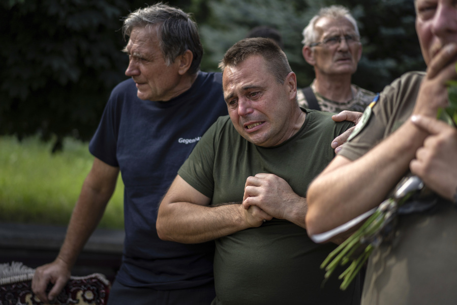 A Ukrainian serviceman reacts as he bids his last farewell to the fallen Ukrainian pilots and crew members of mi-8 military helicopters Volodymyr Rumar, Ivan Yaroviy, Yuriy Anisimov, Valentyn Vorobets, Victor Opanasiuk during a farewell ceremony in Poltava, Ukraine, Friday, Sept. 1, 2023.