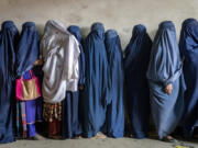 FILE - Afghan women wait to receive food rations distributed by a humanitarian aid group, in Kabul, Afghanistan, Tuesday, May 23, 2023. The mental health of Afghan women, who have suffered under harsh measures imposed by the Taliban since taking power two years ago, has deteriorated across the country, according to a joint report from three U.N. agencies released Tuesday, Sept. 19, 2023.